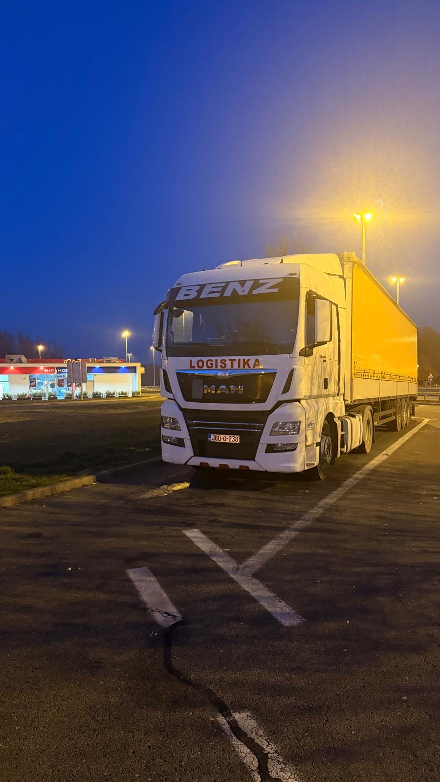 Beli MAN kamion BENZ LOGISTIKA noću pod svetlim lampama
